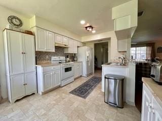 kitchen with sink, white cabinetry, white appliances, and decorative backsplash