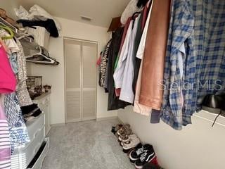 walk in closet featuring light carpet