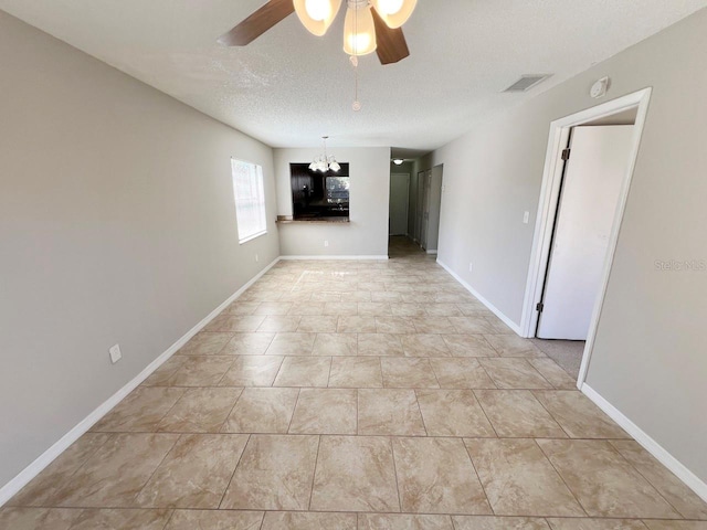 unfurnished room featuring a textured ceiling and ceiling fan with notable chandelier