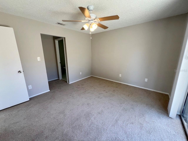 unfurnished bedroom with ceiling fan, light carpet, and a textured ceiling