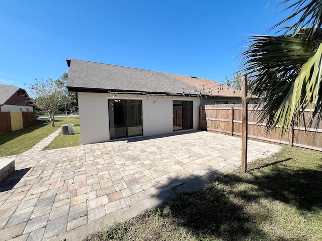 back of property featuring a patio area, a lawn, and central AC unit