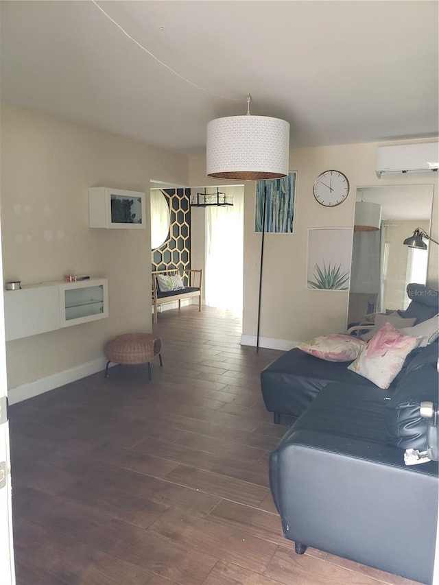 living area with a wall mounted AC, wood finished floors, and baseboards