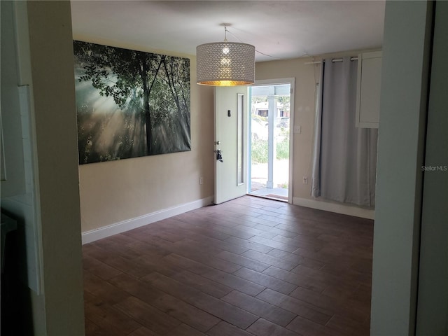 unfurnished room with dark wood-type flooring and baseboards