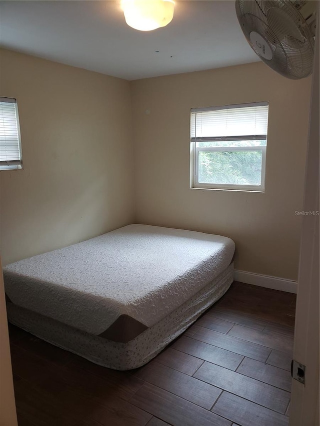 bedroom featuring wood finished floors and baseboards