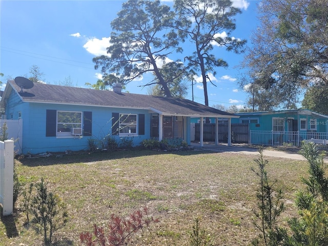 single story home with driveway, fence, and a front yard