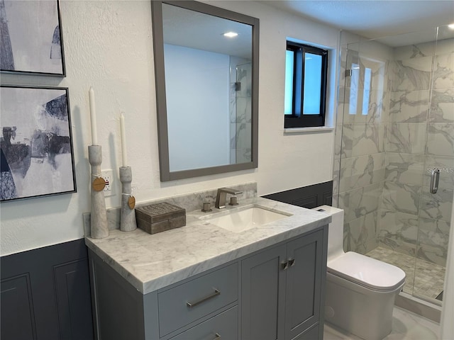 bathroom featuring a shower with shower door, vanity, and toilet