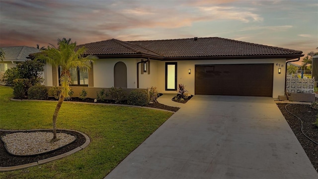 mediterranean / spanish-style home featuring a garage and a yard