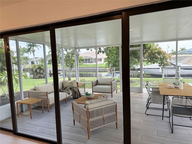 sunroom / solarium featuring a water view