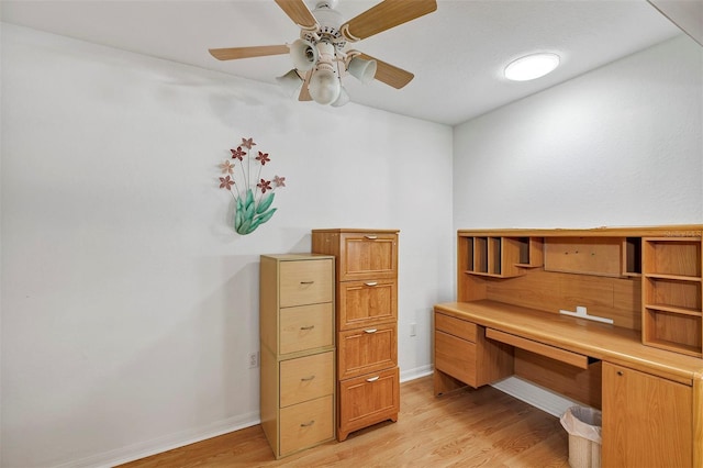 office with built in desk, light wood-type flooring, and ceiling fan