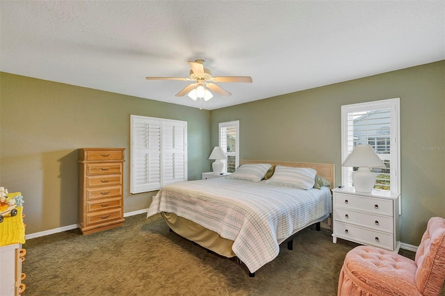 bedroom with dark carpet, multiple windows, and ceiling fan