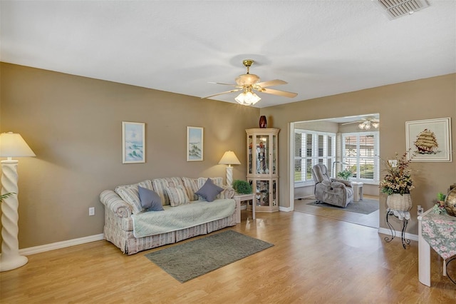 living room with light hardwood / wood-style floors and ceiling fan