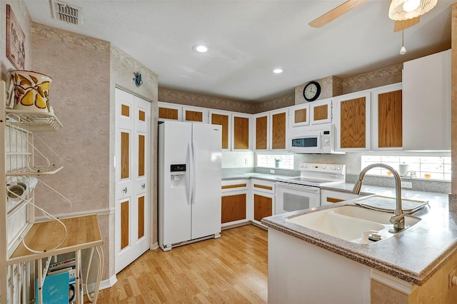 kitchen featuring white appliances, sink, kitchen peninsula, light hardwood / wood-style floors, and ceiling fan