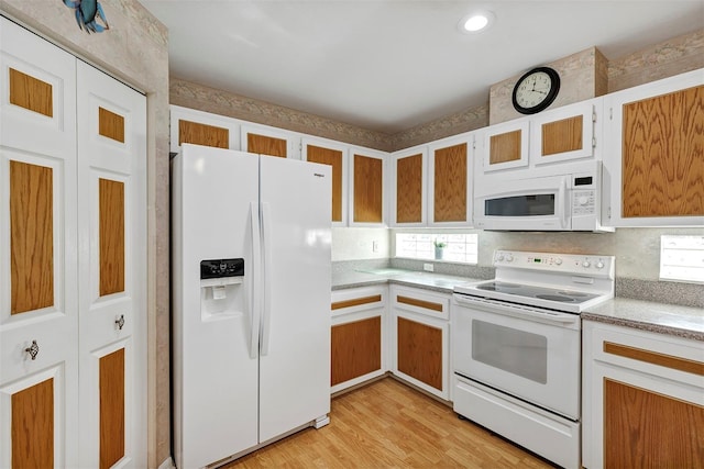 kitchen featuring light hardwood / wood-style flooring, white appliances, and white cabinets