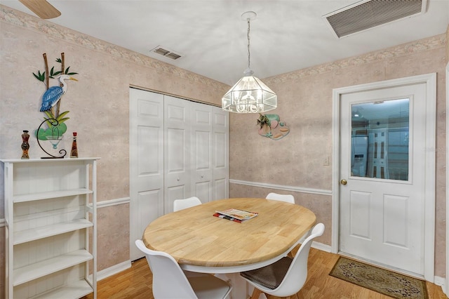 dining space featuring a notable chandelier and light hardwood / wood-style floors