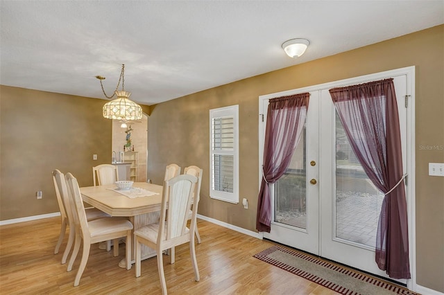 dining area with light hardwood / wood-style floors and french doors