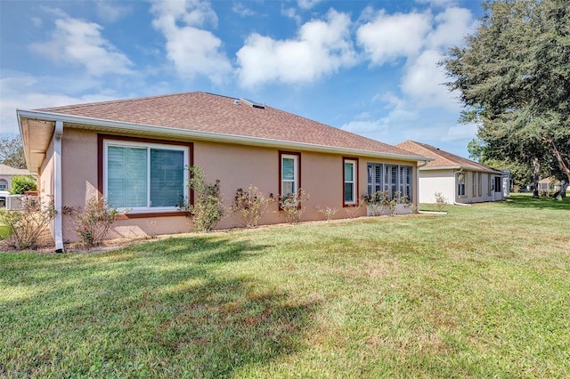 rear view of property featuring a lawn