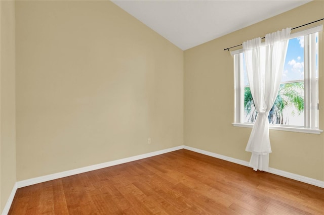 empty room featuring light wood-type flooring and lofted ceiling