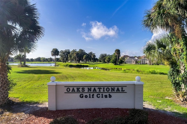 community sign with a yard and a water view