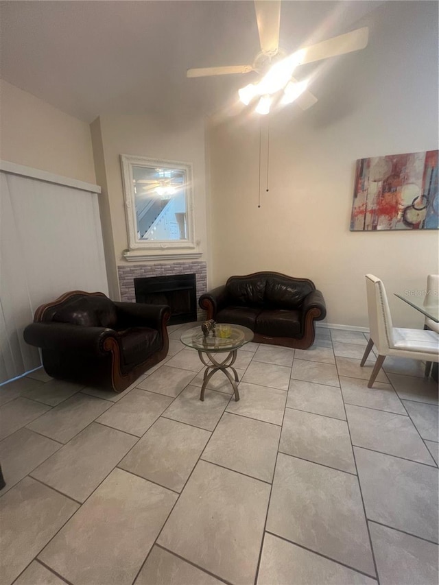 tiled living area featuring ceiling fan and a fireplace