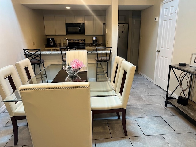 dining space with baseboards and light tile patterned flooring
