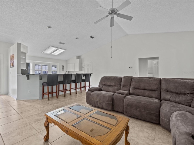 tiled living room with lofted ceiling, a textured ceiling, and ceiling fan