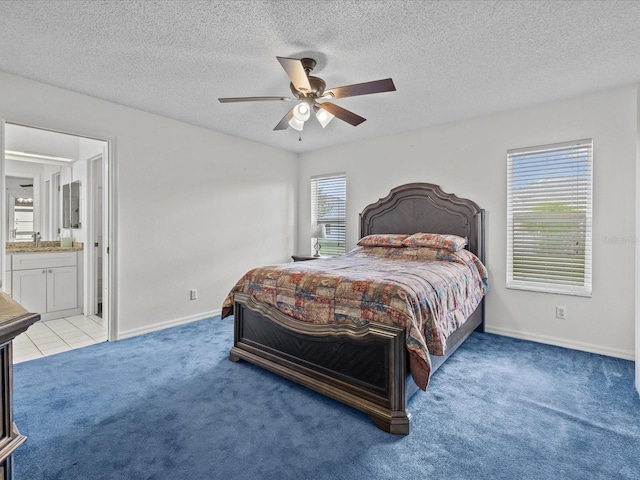 carpeted bedroom with connected bathroom, ceiling fan, and a textured ceiling