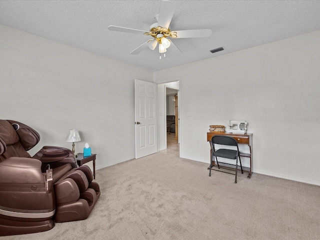 sitting room featuring ceiling fan, light carpet, and a textured ceiling