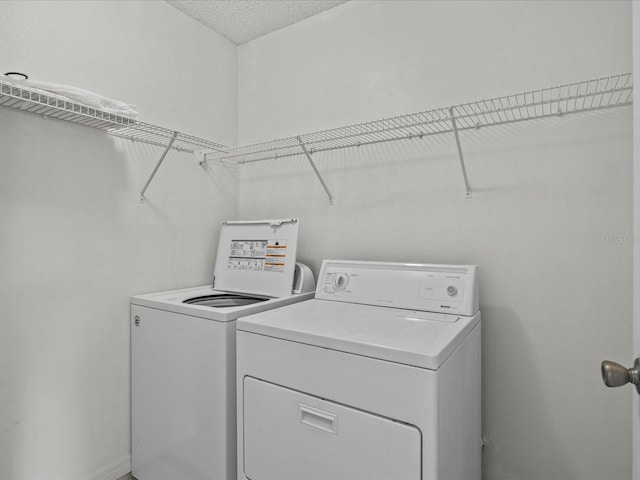 washroom with washer and dryer and a textured ceiling