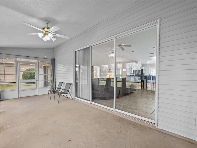 unfurnished sunroom with ceiling fan and vaulted ceiling