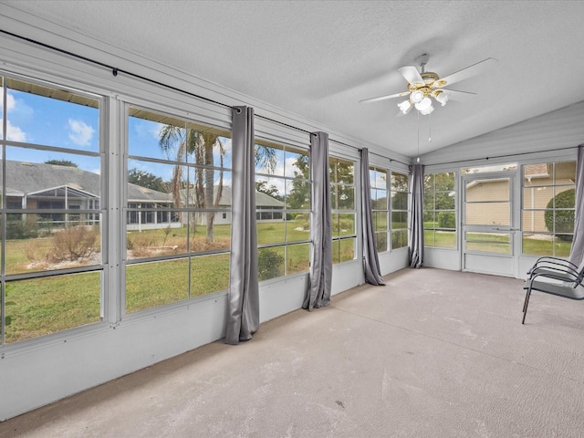 unfurnished sunroom with ceiling fan, vaulted ceiling, and a wealth of natural light