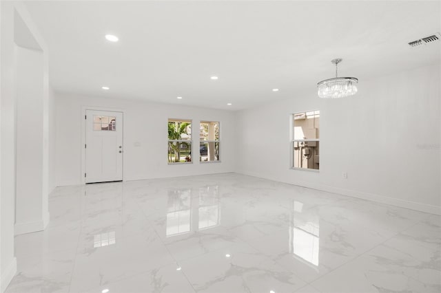 unfurnished room with a chandelier