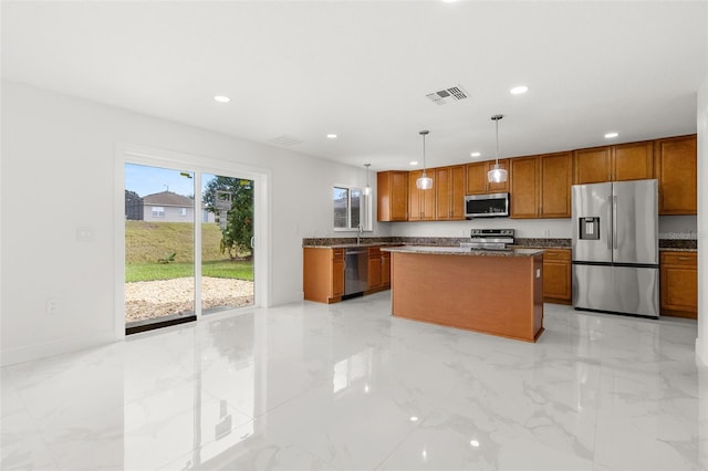 kitchen with a kitchen island, dark stone counters, stainless steel appliances, sink, and decorative light fixtures