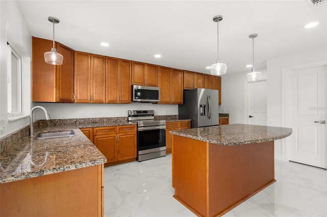 kitchen featuring appliances with stainless steel finishes, sink, a kitchen island, and hanging light fixtures