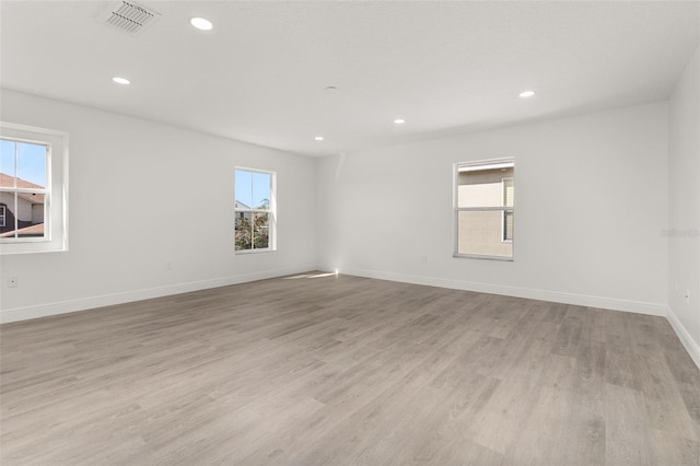 empty room with light wood-type flooring and a wealth of natural light