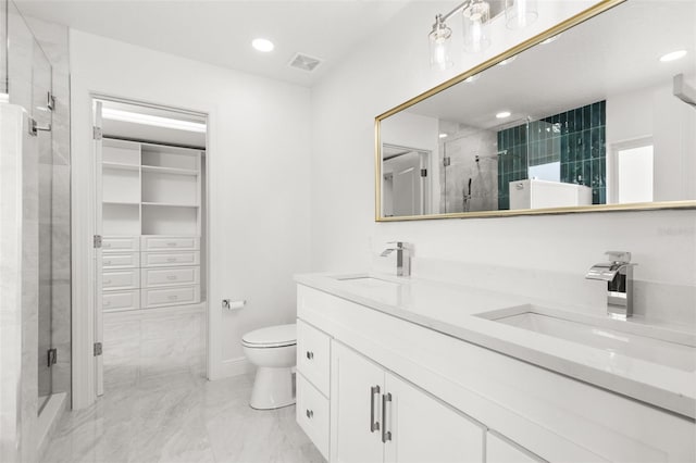 bathroom featuring a shower with door, vanity, and toilet