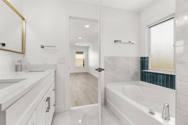 bathroom featuring vanity, hardwood / wood-style floors, and a tub