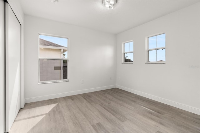 empty room with light hardwood / wood-style flooring and a wealth of natural light