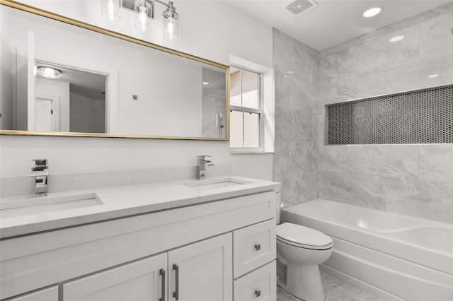 full bathroom featuring toilet, tiled shower / bath combo, and vanity