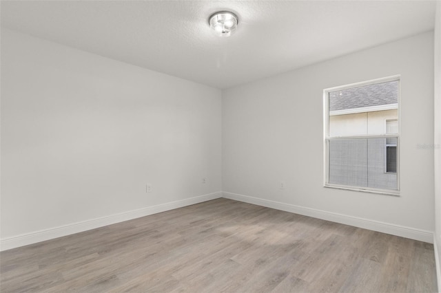 empty room featuring light hardwood / wood-style floors and a textured ceiling