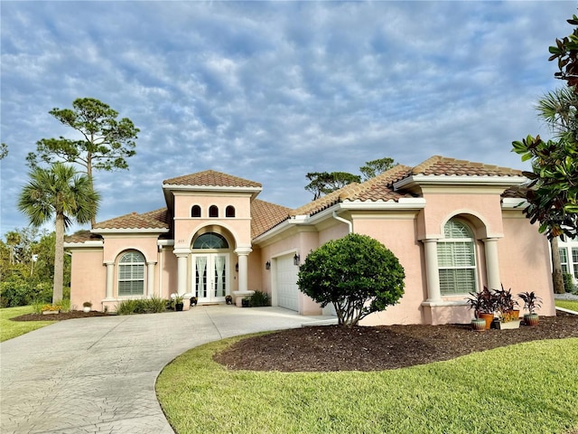 mediterranean / spanish home with a front lawn and a garage