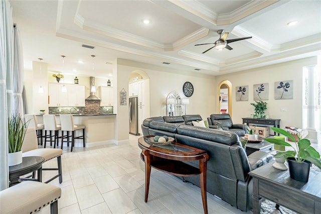 living room featuring ceiling fan, beamed ceiling, crown molding, sink, and coffered ceiling