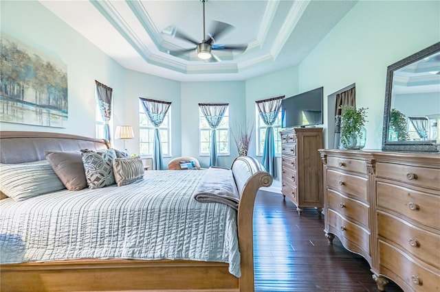 bedroom featuring ornamental molding, a raised ceiling, dark hardwood / wood-style floors, and ceiling fan