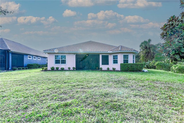 rear view of property featuring a yard and a sunroom