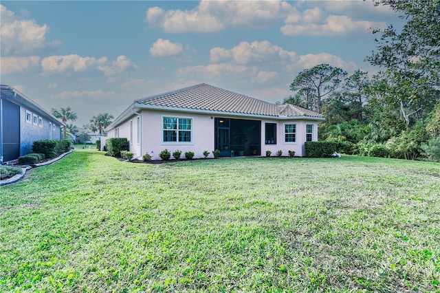 view of front of home featuring a sunroom and a front yard