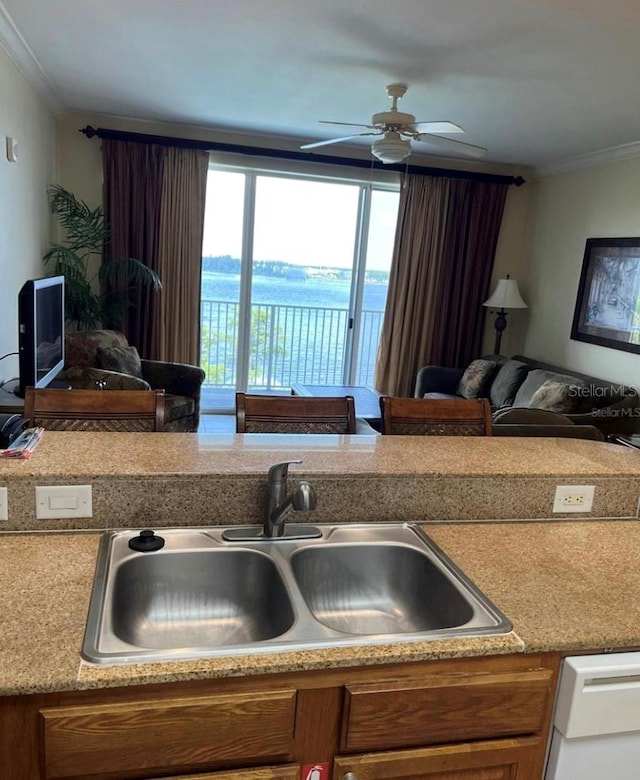 kitchen with ceiling fan, ornamental molding, dishwasher, sink, and a water view