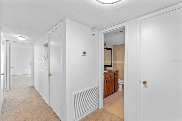 hall featuring electric panel, a textured ceiling, and light carpet