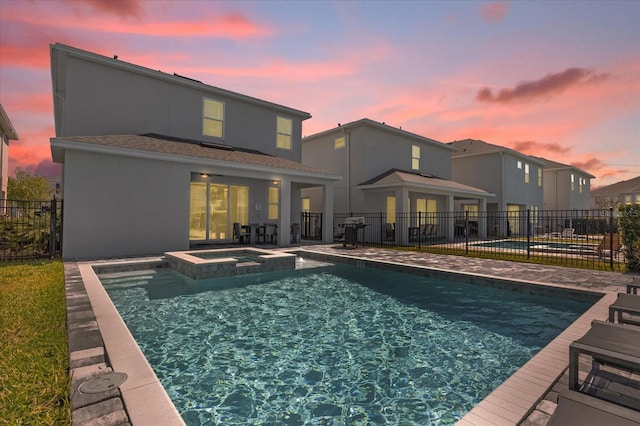 365 Southfield St, Kissimmee, FL 34747 - rear view of house featuring a patio area, a pool with connected hot tub, and stucco siding