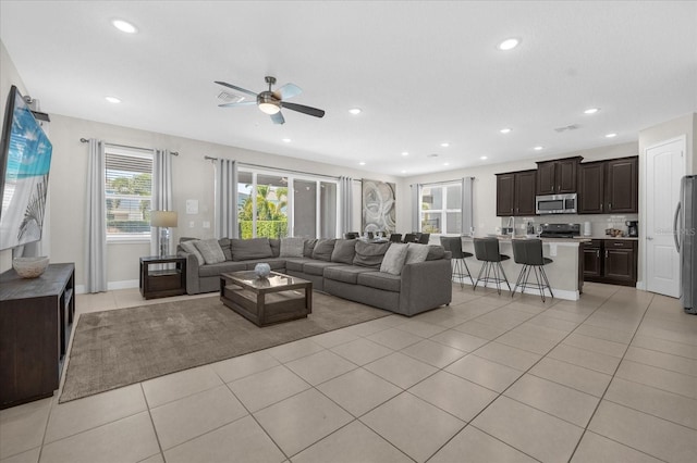 living room featuring light tile patterned floors and ceiling fan