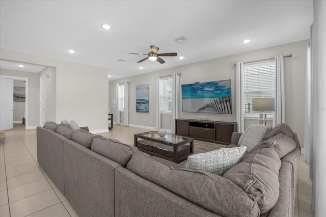 living room with a wealth of natural light, light tile patterned floors, and ceiling fan