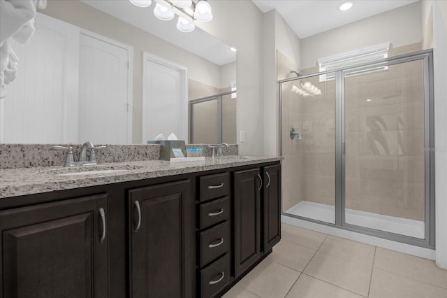 bathroom with tile patterned flooring, vanity, and walk in shower